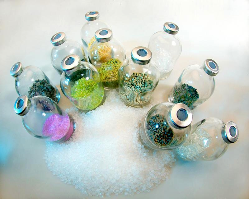 The photo shows several Erlenmeyer flasks with differently coloured granules.